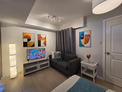 a living room with a couch and a television at 1BR Condotel at Azure Urban Resort Near Airport #AZ04 in Manila