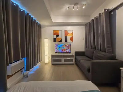 a living room with a couch and a television at 1BR Condotel at Azure Urban Resort Near Airport #AZ04 in Manila