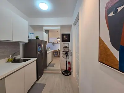 a kitchen with a large painting on the wall at 1BR Condotel at Azure Urban Resort Near Airport #AZ04 in Manila