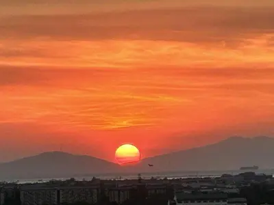 a sunset with the sun setting over a city at 1BR Condotel at Azure Urban Resort Near Airport #AZ04 in Manila