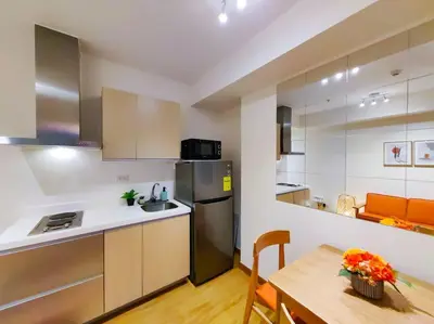 a kitchen and dining room with a table and a refrigerator at 1BR Condotel at Azure Urban Resort Near Airport #AZ02 in Manila