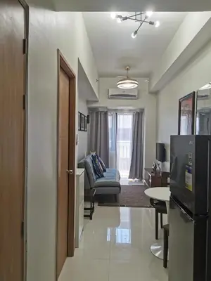 a living room with a couch and a refrigerator at Shore 3 residence mall 'of Asia in Manila