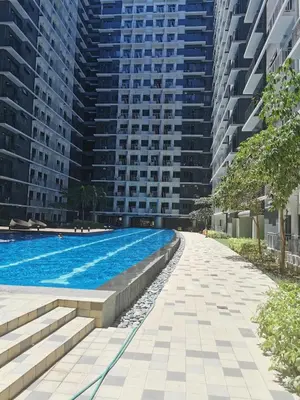 a swimming pool in front of two tall buildings at Shore 3 residence mall 'of Asia in Manila