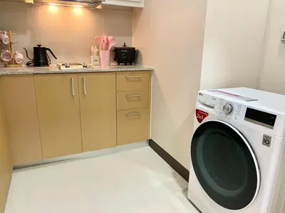 a kitchen with a washing machine in a room at Elegant 1 BR Condo with Balcony in Uptown Parksuites II, BGC in Manila