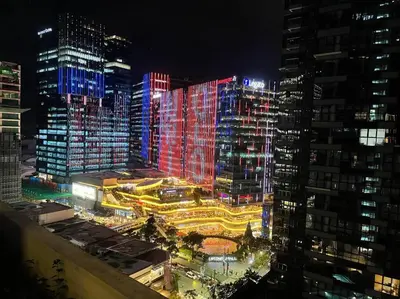 a city lit up at night with tall buildings at Elegant 1 BR Condo with Balcony in Uptown Parksuites II, BGC in Manila