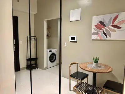 a room with a table and a washing machine at Elegant 1 BR Condo with Balcony in Uptown Parksuites II, BGC in Manila