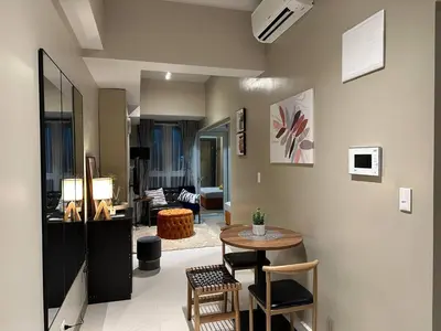 a living room with a table and a living room at Elegant 1 BR Condo with Balcony in Uptown Parksuites II, BGC in Manila
