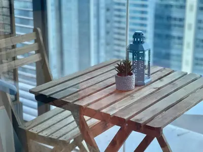 a wooden picnic table with a potted plant on it at Elegant 1 BR Condo with Balcony in Uptown Parksuites II, BGC in Manila