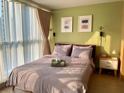a bedroom with a bed with a stuffed animal on it at Elegant 1 BR Condo with Balcony in Uptown Parksuites II, BGC in Manila