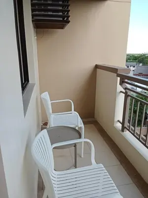 two white chairs and a table on a balcony at Asteria Lovely Staycation in Manila