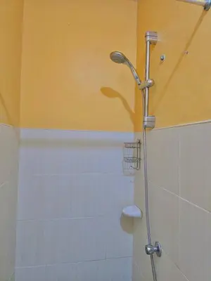 a shower with a shower head in a bathroom at Serenity Acqua Inn Beside Enchanted Kingdom in Santa Rosa