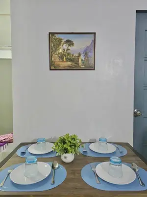 a table with plates and silverware on top of it at Serenity Acqua Inn Beside Enchanted Kingdom in Santa Rosa