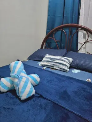 a bed with blue and white socks on it at Serenity Acqua Inn Beside Enchanted Kingdom in Santa Rosa