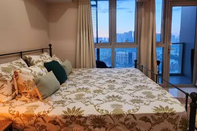 a bedroom with a bed with a view of the city at BGC Uptown Parksuites King Bed with Balcony Sunset and City View in Manila