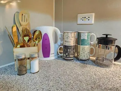 a counter with jars and utensils on a counter top at BGC Uptown Parksuites King Bed with Balcony Sunset and City View in Manila