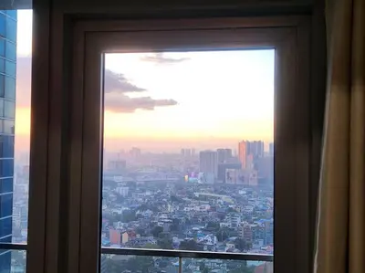 a window with a view of a city at BGC Uptown Parksuites King Bed with Balcony Sunset and City View in Manila