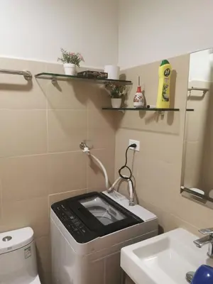 a small bathroom with a washing machine and a sink at Moa shore 3 residence in Manila