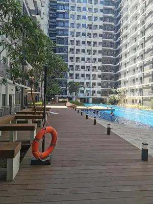 a swimming pool with a orange life preserver on a boardwalk at Moa shore 3 residence in Manila
