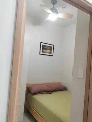 a bedroom with a bed and a ceiling fan at Moa shore 3 residence in Manila