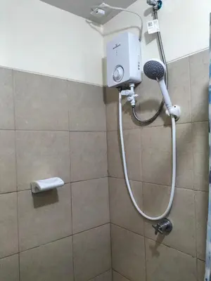 a shower with a shower head in a bathroom at STANFORD SUITES 3 in Silang