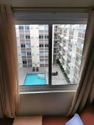 a window with a view of a swimming pool at STANFORD SUITES 3 in Silang