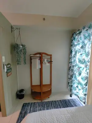 a bedroom with a bed and a wooden cabinet at Comfy unit at SMDC Breeze Residences near PICC, MOA, NAIA Airport, CCP with a view! in Manila