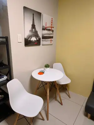 a white table and chairs in a room with the eiffel tower at Comfy unit at SMDC Breeze Residences near PICC, MOA, NAIA Airport, CCP with a view! in Manila