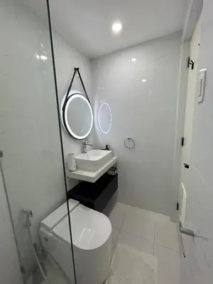 a bathroom with a toilet and a sink and a mirror at Relax in style: Modern Airbnb and Netflix in Manila