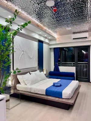a bedroom with a large bed and a blue couch at Deluxe Executive Corner Unit in Makati in Manila