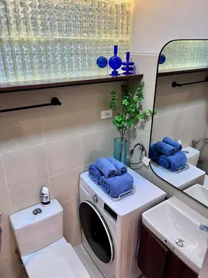 a bathroom with a washing machine and a sink at Deluxe Executive Corner Unit in Makati in Manila