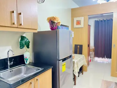 a kitchen with a stainless steel refrigerator and a sink at Shell Residences Condo Suite Staycation near MOA and Airport in Manila