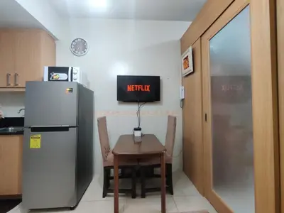 a small kitchen with a table and a refrigerator at Shell Residences Condo Suite Staycation near MOA and Airport in Manila