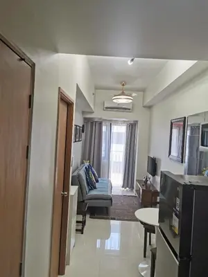 a living room with a couch and a chair in a room at Moa shore 3 staycation in Manila