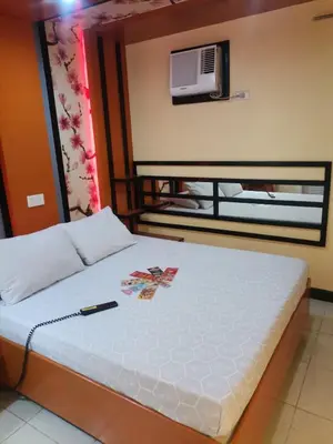 a bedroom with a bed with a white bedspread at Hotel Sogo Alabang Southroad in Manila