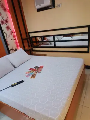 a white bed with a pen on top of it at Hotel Sogo Alabang Southroad in Manila