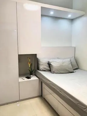 a small bedroom with a bed with a white cabinet at Cozy 1-bedroom unit in Shore 3 Residences in Manila