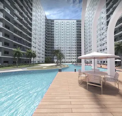 a swimming pool with a table and umbrella next to buildings at Cozy 1-bedroom unit in Shore 3 Residences in Manila
