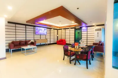 a living room with a couch and a table and chairs at Hotel Sogo Guadalupe in Manila