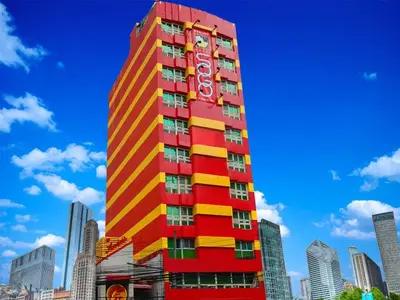 a red and yellow building with a sign on it at Hotel Sogo Makati Avenue in Manila