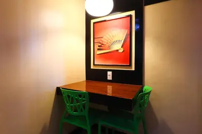 a room with a table and two green chairs at Hotel Sogo Makati Avenue in Manila
