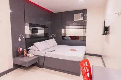 a small bedroom with a bed with a red accent at Hotel Sogo Cainta in Manila