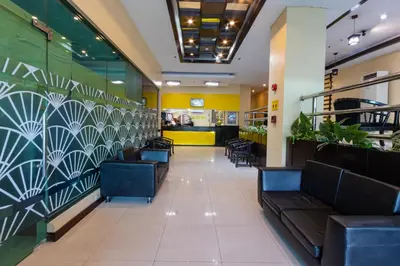 a restaurant with couches and a wall with plants at Hotel Sogo Cainta in Manila