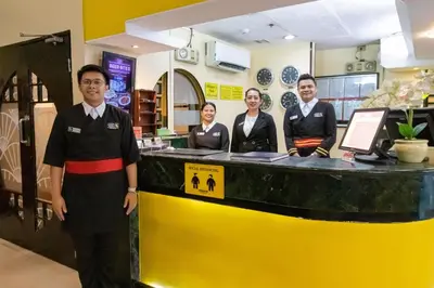 a group of people standing in front of a counter at Hotel Sogo Cainta in Manila