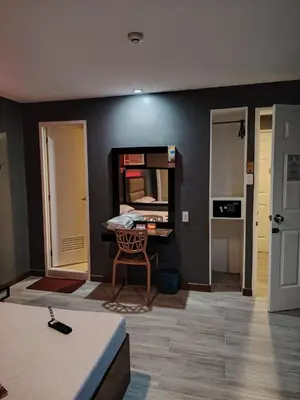 a room with a black wall with a chair and a desk at Hotel Sogo Quirino in Manila