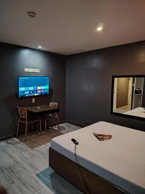 a room with a bed and a desk and a tv at Hotel Sogo Quirino in Manila