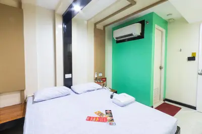 a bedroom with a white bed with a green wall at Hotel Sogo Kalentong in Manila