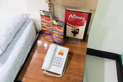 a telephone on a table next to a bed at Hotel Sogo Kalentong in Manila