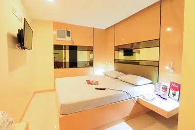 a bedroom with a large bed and a mirror at Hotel Sogo Alabang Rotonda in Manila