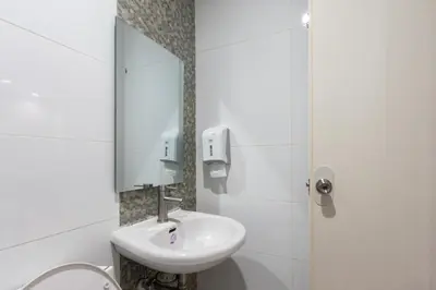 a white bathroom with a sink and a mirror at Hotel Sogo Alabang Rotonda in Manila