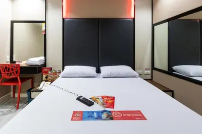 a bedroom with a bed with a magazine on it at Hotel Sogo Alabang Rotonda in Manila